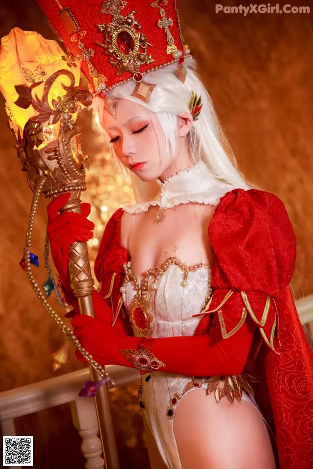 A woman dressed in a red and white outfit holding a torch.