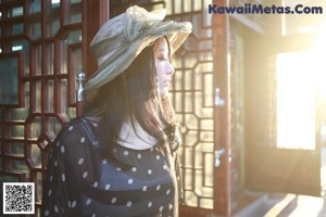 A woman in a black and white polka dot dress and hat.