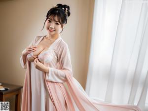 A woman in a white kimono posing for a picture.