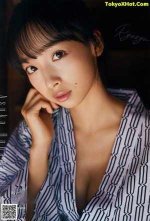 A woman in a white bodysuit posing for a magazine.