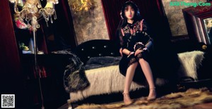 A woman sitting in a rocking chair holding a fan.