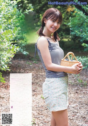 A woman in a white dress holding a piece of food.