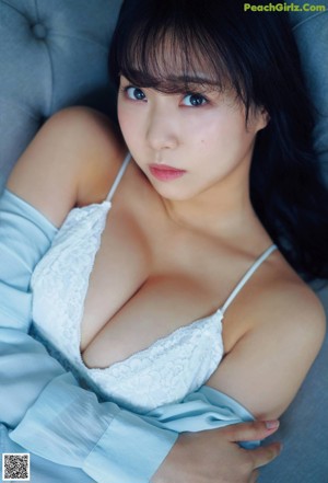A woman in a white lingerie leaning against a window.