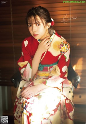 Two women in kimonos standing next to each other. 
