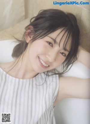 A young woman with long black hair and a striped shirt.
