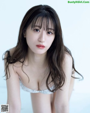 A woman laying on a bed in a blue lingerie.