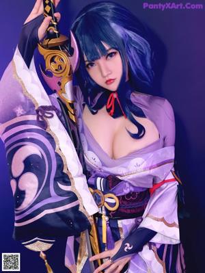 A woman with long black hair wearing a purple outfit.