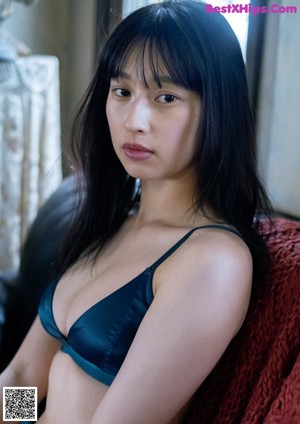 A woman sitting on a couch in a purple bra and panties.